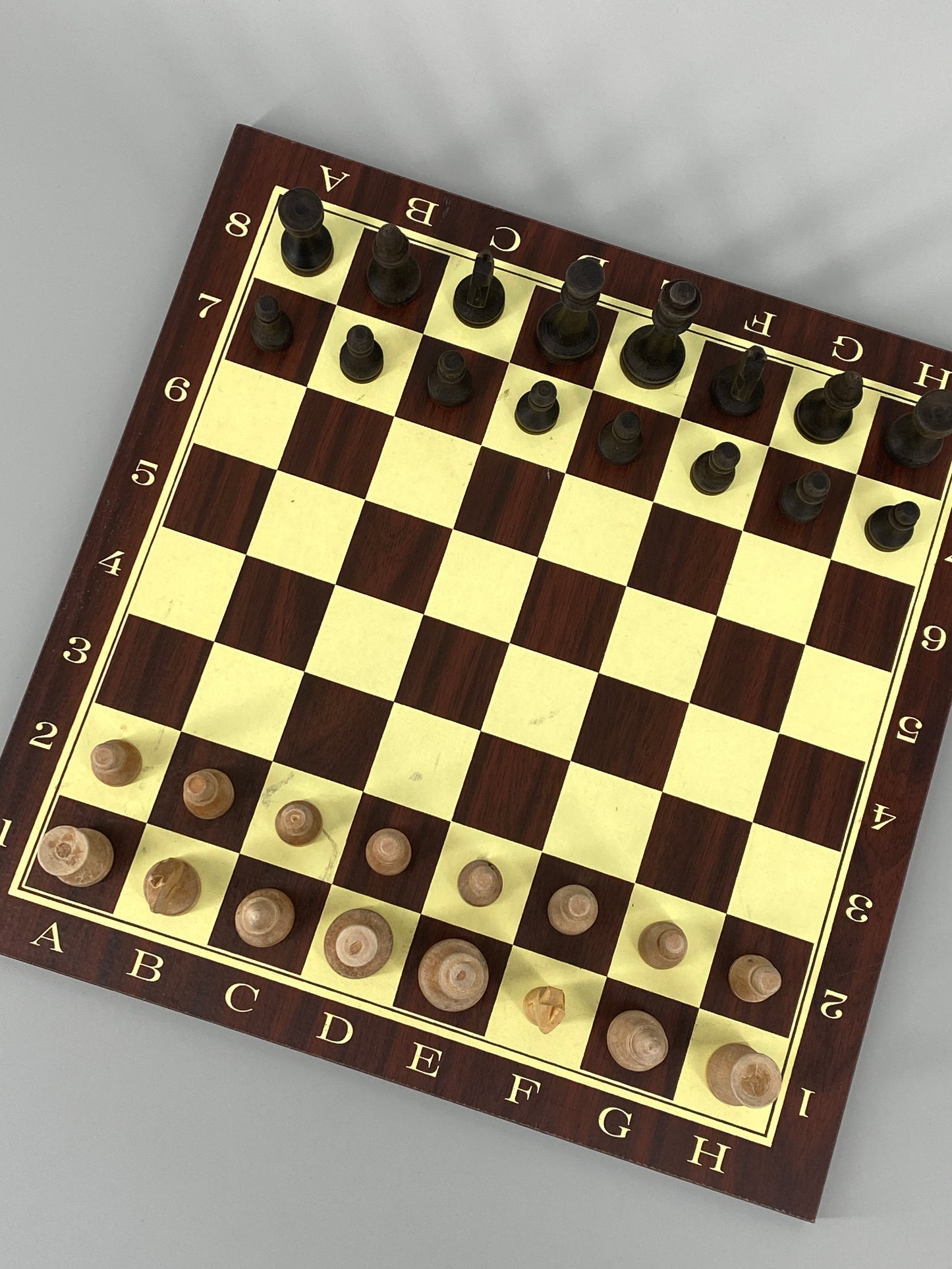 Beidseitiges Schachbrett / Mühlespiel mit moderner Typografie und einem Set Schachfiguren