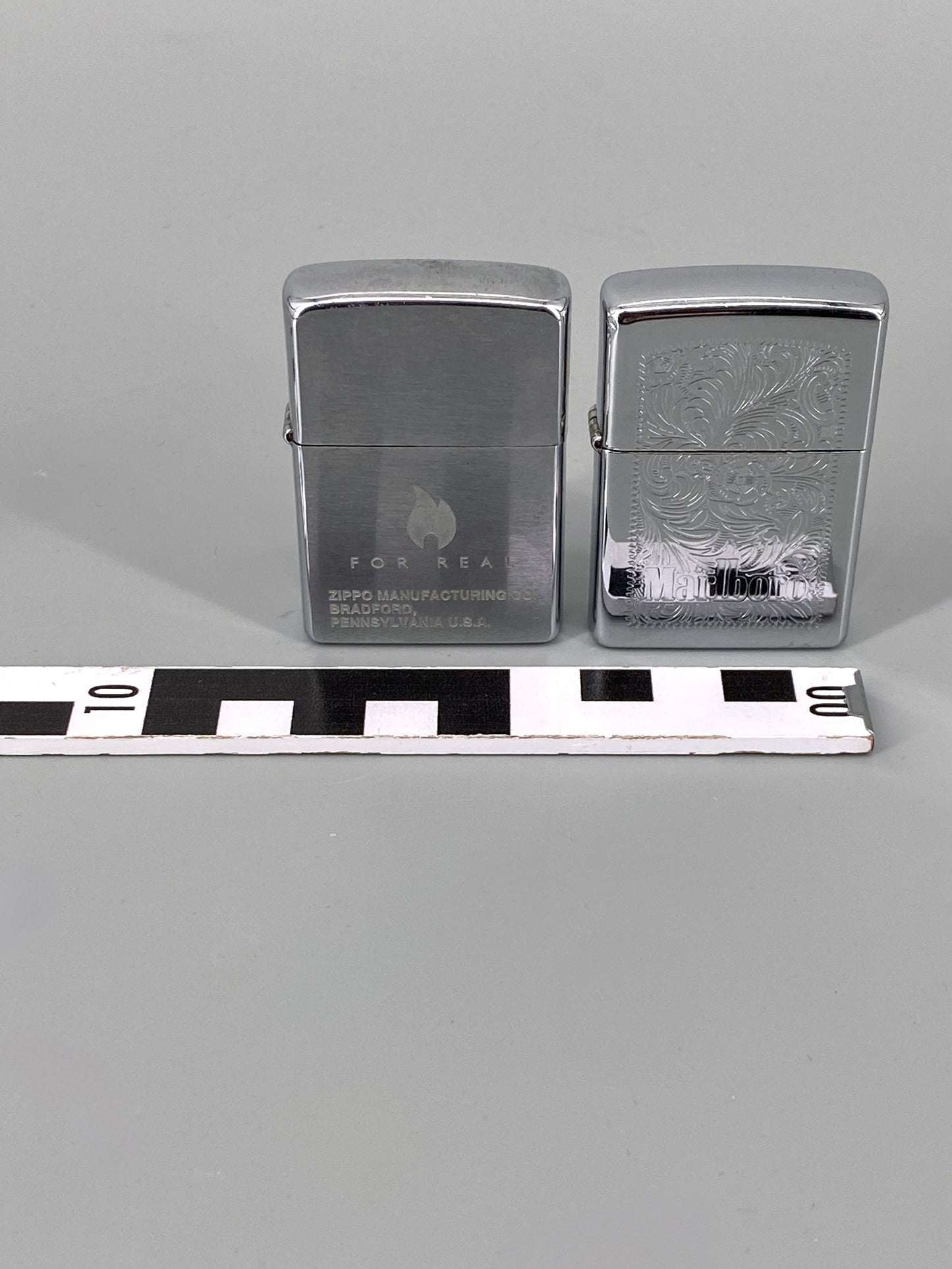 2 Zippo Benzinfeuerzeuge, "Marlboro" und "For Real"