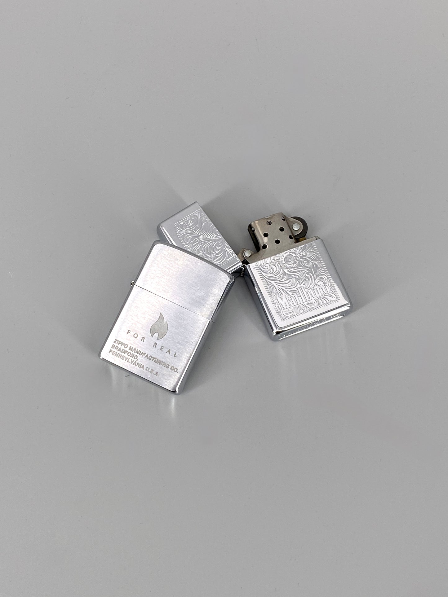 2 Zippo Benzinfeuerzeuge, "Marlboro" und "For Real"