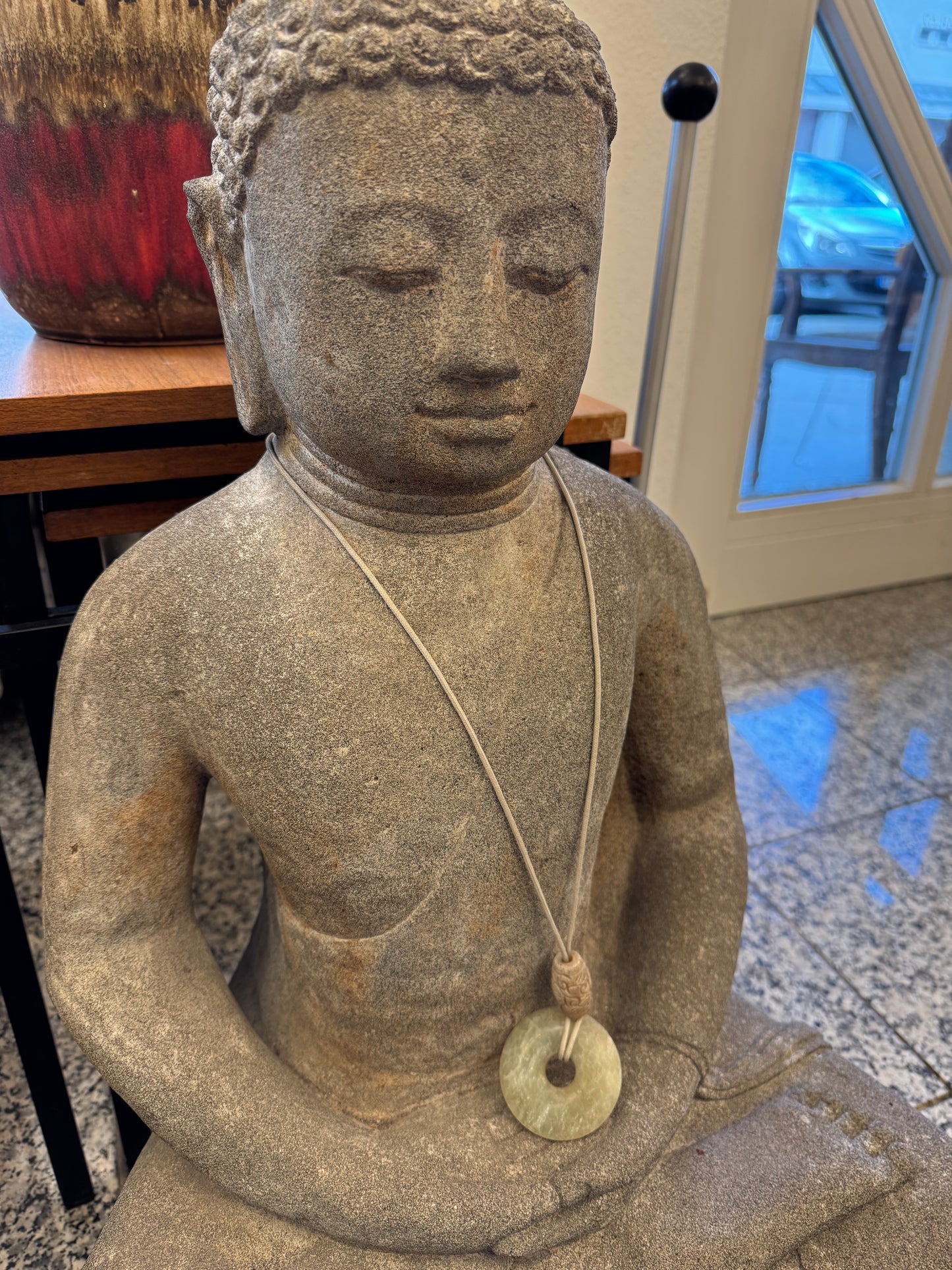 Sitzende Buddhafigur aus Naturstein mit serpentinen Halskette
