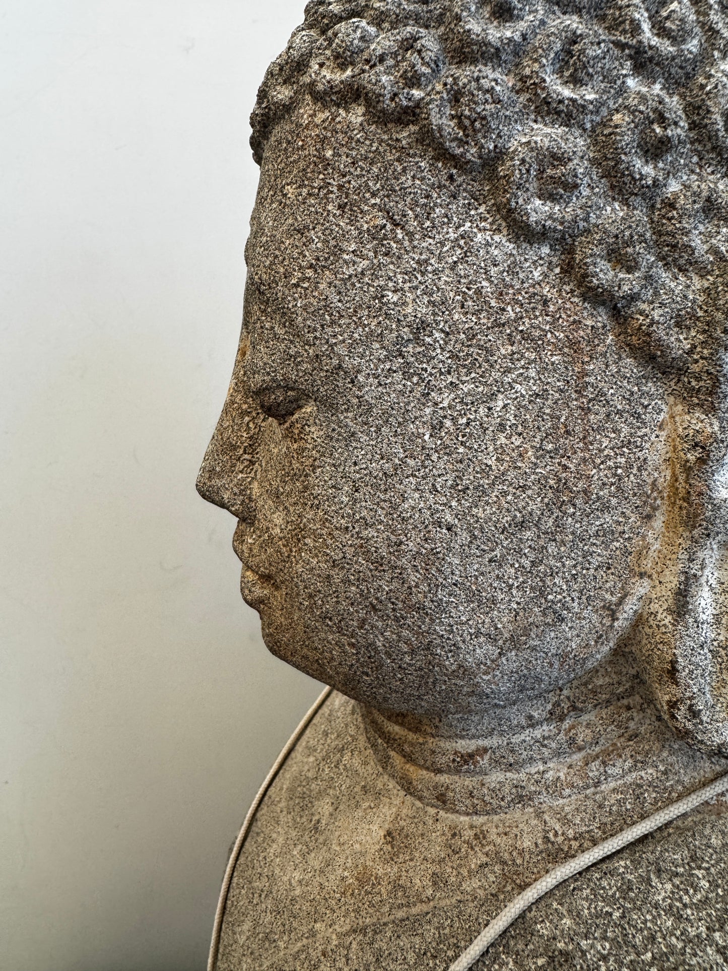 Sitzende Buddhafigur aus Naturstein mit serpentinen Halskette