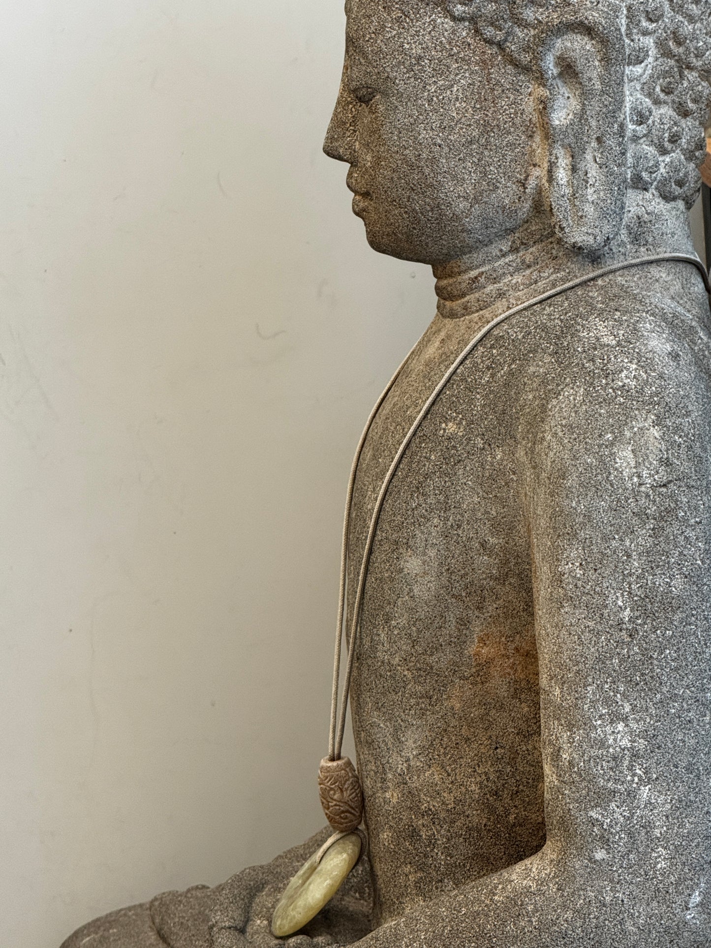 Sitzende Buddhafigur aus Naturstein mit serpentinen Halskette
